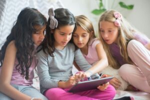 Close-Up Shot of Four Girls Looking at the Ipad
