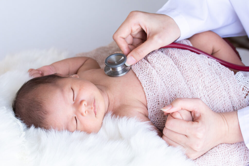stock photo of newborn baby being checked with a stethoscope on their chest